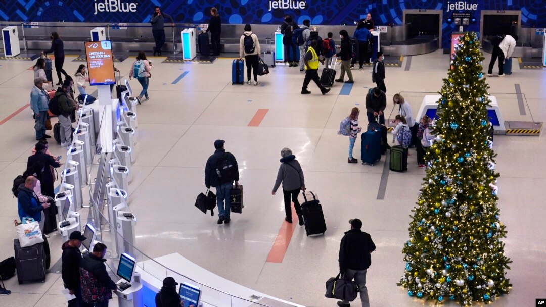 Sejumlah penumpang tampak hilir mudik di area gerbang Terminal C Bandara Internasional Logan di Boston, pada 21 November 2022. (Foto: AP/Charles Krupa) 