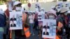 NagaWorld casino workers hold posters and banners during a rally in Phnom Penh on January 4, 2022. Union leader Chhim Sithar was arrested that day en route to join the strike. (Heng Sinith/Associated Press) 