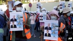 NagaWorld casino workers hold posters and banners during a rally in Phnom Penh on January 4, 2022. Union leader Chhim Sithar was arrested that day en route to join the strike. (Heng Sinith/Associated Press) 