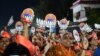 Bharatiya Janata Party (BJP) supporters hold danglers portraying Indian prime minister Narendra Modi during a political rally ahead of Gujarat's assembly election at Naroda in Ahmedabad on Nov. 25, 2022. 