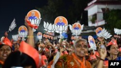 Bharatiya Janata Party (BJP) supporters hold danglers portraying Indian prime minister Narendra Modi during a political rally ahead of Gujarat's assembly election at Naroda in Ahmedabad on Nov. 25, 2022. 