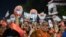 Bharatiya Janata Party (BJP) supporters hold danglers portraying Indian prime minister Narendra Modi during a political rally ahead of Gujarat's assembly election at Naroda in Ahmedabad on Nov. 25, 2022. 