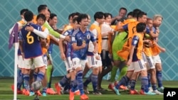 Japan players celebrate after Takuma Asano scored his side's second goal during the World Cup group E soccer match between Germany and Japan, at the Khalifa International Stadium in Doha, Qatar, Nov. 23, 2022. 