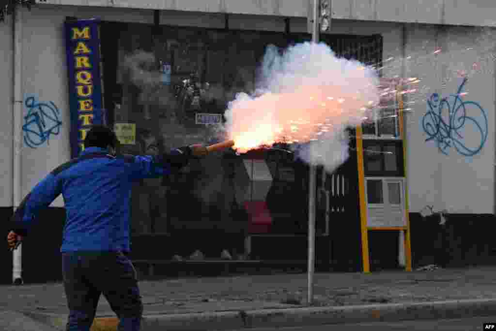 A supporter of the ruling Movement To Socialism fires a petard to opposers to President Luis Arce during a protest march &quot;for democracy, freedom, and justice,&quot;&nbsp;demanding the release of the governor of Santa Cruz, Luis Fernando Camacho, in La Paz, Bolivia, Jan. 10, 2023.