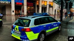 Vehículos policiales estacionados alrededor de un área acordonada en Altmarkt Galerie durante una toma de rehenes en Dresde, Alemania, el sábado 10 de diciembre de 2022. (Jorg Schurig/spa vía AP)