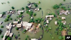 FILE - Homes are surrounded by floodwaters in Sohbat Pur city, a district of Pakistan's southwestern Baluchistan province, Aug. 30, 2022.