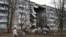 A woman passes by an apartment building damaged following by Russian shelling in Bakhmut, the site of the heaviest battles with the Russian troops, in the Donetsk region, Ukraine, Dec. 11, 2022. 