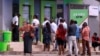 FILE - People queue at ATMs in Abuja, Nigeria, March 30, 2020.