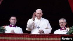 Pope Francis waves as he delivers his traditional Christmas Day Urbi et Orbi message to the city and the world from the main balcony of St. Peter's Basilica at the Vatican, Dec. 25, 2022. 