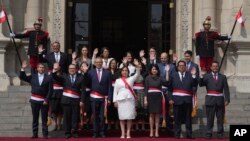 Presiden Peru Dina Boluarte, depan tengah, dan anggota kabinet yang baru diangkat melambai saat mereka berfoto bersama setelah upacara pelantikan, di tangga istana pemerintah di Lima, Peru, 10 Desember 2022. (Foto: AP )