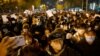 Protesters march along a street during a rally for the victims of a deadly fire as well as a protest against China's harsh COVID-19 restrictions in Beijing on Nov. 28, 2022. 