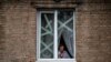 Жінка у вікні будівлі в місті Часів Яр біля Бахмута в Донецькій області, де відбуваються найзапекліші бої на цьому етапі російської війни проти України. 5 січня 2023 р.
