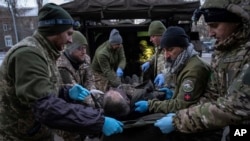 Ukrajinske snage evakuišu povređenog vojnika sa ratišta u Donjecku (Foto: AP/Evgeniy Maloletka)