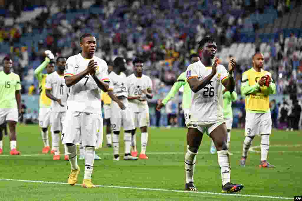 Attaquant ya Ghana #07 Abdul Fatawu Issahaku, défenseur ya Ghana #26 Alidu Seidu mpe na basani ba ekipi na bango basusu bazali kopesa longonya na bakumisa ba bango nsima kopola 0-2 liboso lya Uruguay mpe kolongwa na Mondial Qatar 2022 na stade Al-Janoub, 