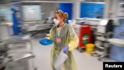 FILE - A nurse treats COVID-19 patients in the Intensive Care Unit at Milton Keynes University Hospital in Britain, Jan. 20, 2021. 
