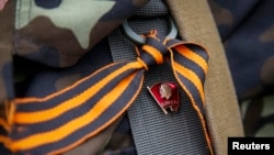 Un rebelde prorruso del Batallón Vostok (Este) lleva una insignia con el fundador del estado soviético Vladimir Lenin y una cinta naranja de San Jorge, símbolo ampliamente asociado con las protestas prorrusas en Ucrania. En un puesto de control en Donetsk,, el 1 de junio de 2014.