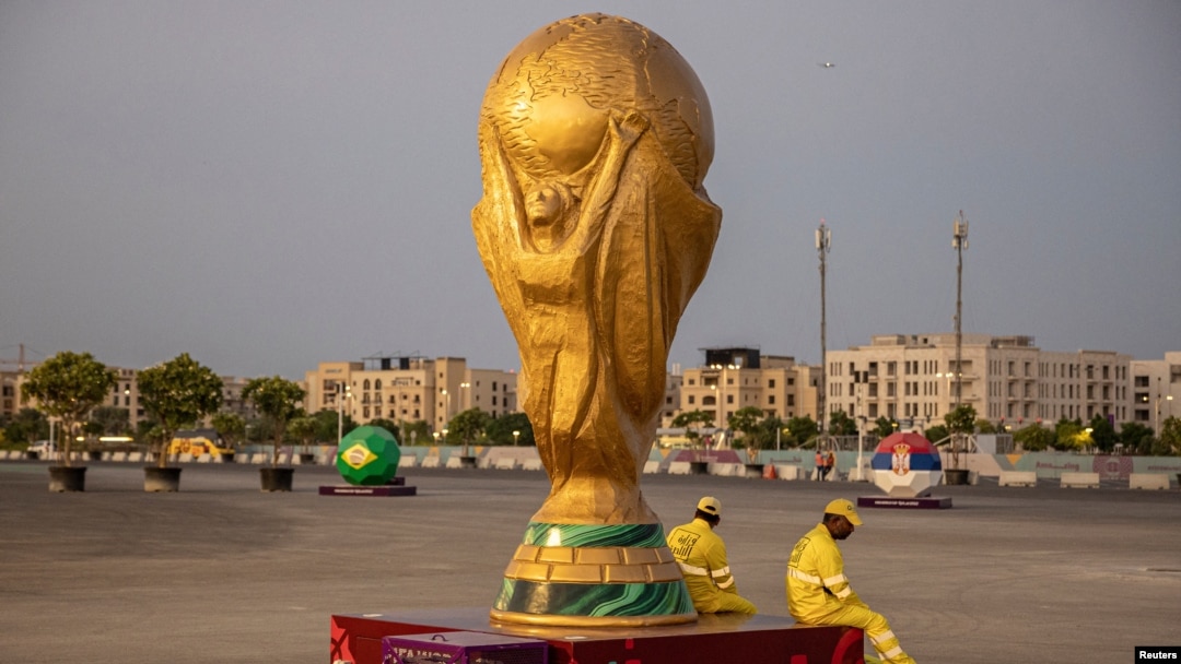 Pekerja duduk di samping replika Piala Dunia di luar Stadion Lusail jelang Piala Dunia, di Lusail, Qatar, 10 November 2022 REUTERS/Marko Djurica