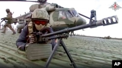 Russian soldiers take their position upon landing at an unspecified location in Ukraine, in this handout photo taken from video released by Russian Defense Ministry Press Service on Dec. 6, 2022.