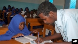 FILE - A Somali teacher explains the lesson to students inside a school classroom in Mogadishu, Somalia. 