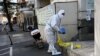 A worker wearing personal protective equipment (PPE) during the Covid-19 pandemic is seen along a street in Beijing, China, Dec. 11, 2022. 