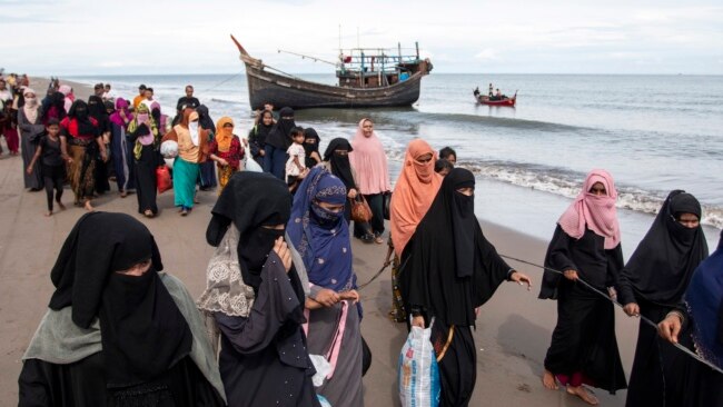 FILE - Ethnic Rohingya refugees walk to a temporary shelter after they landed on their wooden boat in North Aceh, Indonesia, Nov. 16, 2022.