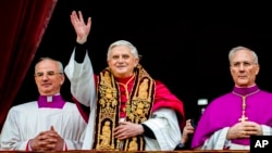 FILE - Pope Benedict XVI, flanked by Monsignor Francesco Camaldo, left, and Bishop Piero Marini, greets the crowd from the central balcony of St. Peter's Basilica at the Vatican soon after his election on April 19, 2005. 