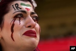 An Iranian woman, name not given, breaks into tears after a member of security seized her flag reading "Woman Life Freedom" before the start of the World Cup group B soccer match between Wales and Iran, at the Ahmad Bin Ali Stadium in Al Rayyan, Qatar.