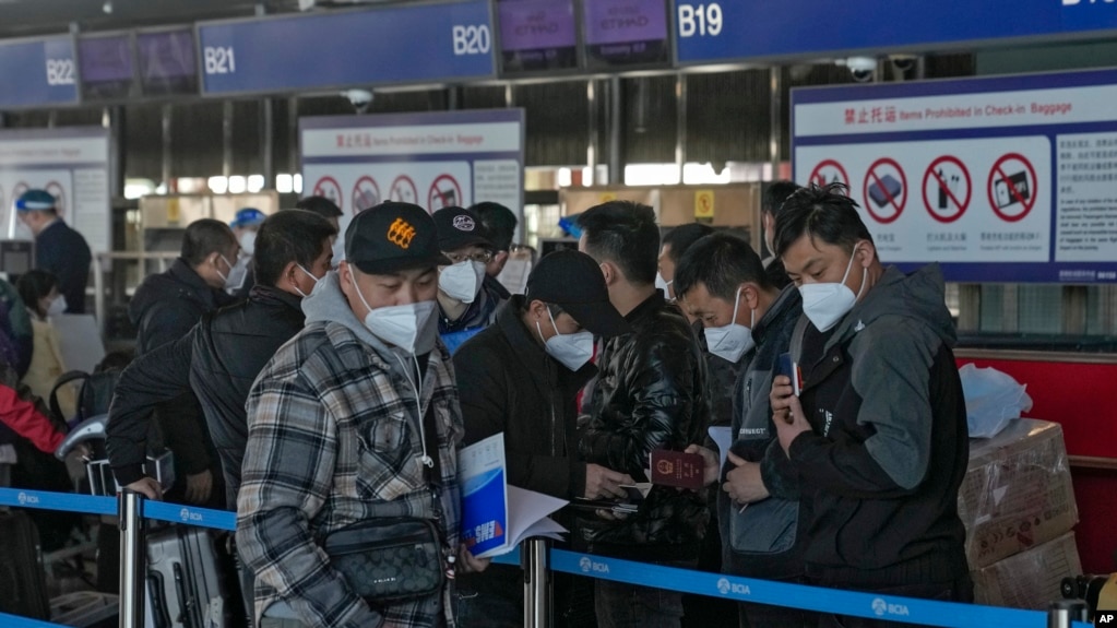 北京国际机场一个国际航班柜台排队的手持中国护照的乘客。（2022年12月29日）(photo:VOA)