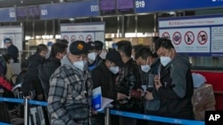 北京国际机场一个国际航班柜台排队的手持中国护照的乘客。（2022年12月29日）