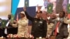 FILE: Sudan's Army chief Abdel Fattah al-Burhan (C R) and paramilitary commander Mohamed Hamdan Dagalo (C L) lift documents alongside civilian leaders following the signing of an initial deal in the capital Khartoum on December 5, 2022. 