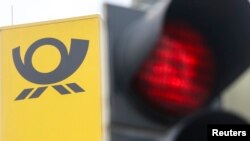 ILUSTRASI - Logo perusahaan pengiriman surat Jerman Deutsche Post terlihat di sebelah lampu merah di Munich, Jerman, 18 Juni 2015. (REUTERS/Michael Dalder).