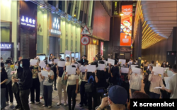 香港中环商业区民众手举白纸参加抗议活动。(2022年11月28日)