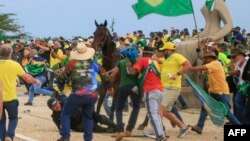 Un policía militar cae de su caballo en medio de choques con partidarios del expresidente Jair Bolsonaro en Brasilia, Brasil, el 8 de enero de 2023.