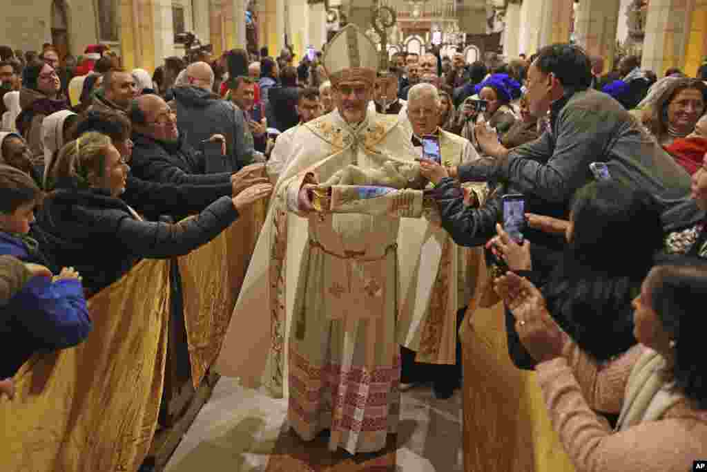 The acting Latin Patriarch of Jerusalem Pierbattista Pizzaballa leads a Christmas midnight Mass at the Church of the Nativity compound in the West Bank town of Bethlehem.