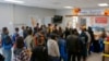 ARCHIVO - Varias personas hacen fila en el centro de bienvenida a migrantes frente a la estación de autobuses, el viernes 16 de diciembre de 2022, en Brownsville, Texas. 