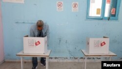 A man votes at a polling station during parliamentary election in Tunis, Tunisia Dec. 17, 2022. 