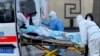 北京医护人员将一名病人运往朝阳医院发热门诊。（2022年12月13日）