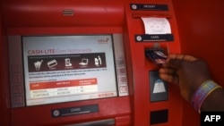 FILE: A customer withdraws money from an automated teller machine (ATM) at a branch of United Bank of Africa (UBA) in Asaba, Delta State, Nigeria, on November 10, 2016.