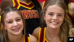 In this image provided by Janae Montgomery, Caroline Gill, left, and Maggie Dunn are shown in their cheerleading uniforms at Brusly High School in Brusly, Louisiana. Gill and Dunn were killed Dec. 31, 2022, when the car they were riding in was struck by a police car.