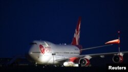 Cosmic Girl, sebuah pesawat Virgin Boeing 747-400, membawa peluncur roket Virgin Orbit yang terpasang pada bagian sayapnya. Pesawat tersebut tengah bersiap untuk lepas landas dari Bandara Newquay, Inggris, pada 9 Januari 2023. (Foto: Reuters/Henry Nicholls)