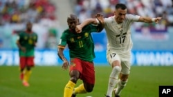 Cameroon's Christian Bassogog, left, fights for the ball with Serbia's Filip Kostic during the World Cup group G soccer match between Cameroon and Serbia, at the Al Janoub Stadium in Al Wakrah, Qatar, Nov. 28, 2022. 