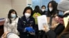 An officer collects passports from residents for renewal and re-applications at a community police station in Beijing, Dec. 28, 2022. 