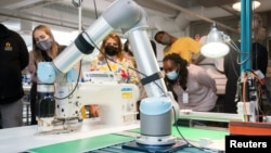 FILE - A robotic arm positions pieces of stiffened fabric for a demonstration of automated sewing at the Industrial Sewing and Innovation Center in Detroit, Michigan, U.S. August 19, 2021. (Industrial Sewing and Innovation Center/Handout via REUTERS) 