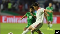 资料照片：伊朗国家足球队员加富里（右）在亚洲杯比赛中与伊拉克队争球(2019年1月16日）
