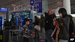 Hành khách đeo khẩu trang xếp hàng kiểm tra an ninh để vào cổng khởi hành quốc tế tại Sân bay Quốc tế Thủ đô Bắc Kinh ở Bắc Kinh, vào ngày 29/12/2022.