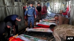 The bodies of Iraq's federal police members who were killed in suspected IS attack, are repatriated from Kirkuk airport in northern Iraq on Dec. 18, 2022.