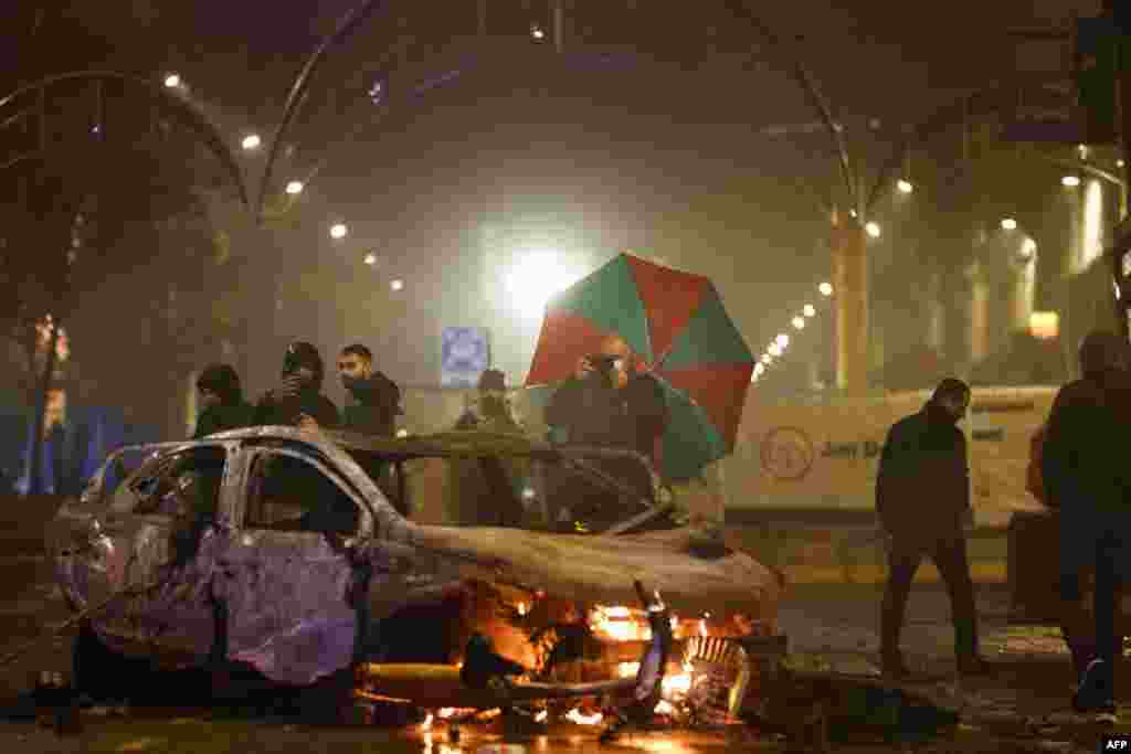 Moto moko azali kokanga photo ya motuka etumbami na nzela na Bruxelles (Belgique), nsima na Belgique kopola 0-2 na Maroc, na match ya groupe F ya Mondial Qatar 2022, 28 novembre 2022. (Photo Kenzo TRIBOUILLARD / AFP)