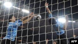 FILE - Uruguay's Luis Suarez (L) stops the ball with his hand preventing a goal by Ghana in a 2010 FIFA World quarter-final at AFP Soccer City Stadium in Soweto, July 2, 2010, South Africa
