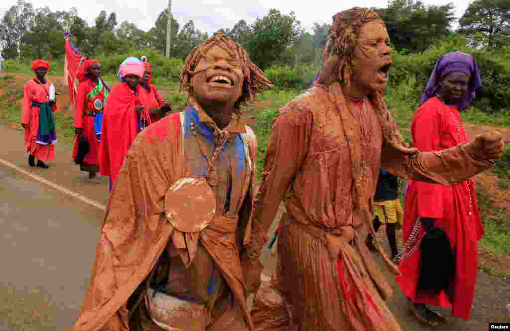 Believers of the Legio Maria of African Church Mission covered in mud, attend a procession as part of their Christmas Mass near Ugunja, in Siaya County, Kenya.