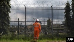 An employee at the Shell Agbada 2 flow station talks on a walkie-talkie at the entrance of the station in Port Harcourt on September 30, 2015.